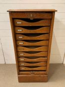 An oak Tambour filing cabinet, nine sliding drawers with original lock and keys (H101cm W50cm