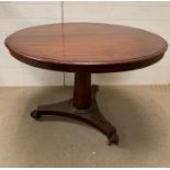 A Regency style breakfast table the tilt top on faceted shaft on a tri-form platform base (H72cm