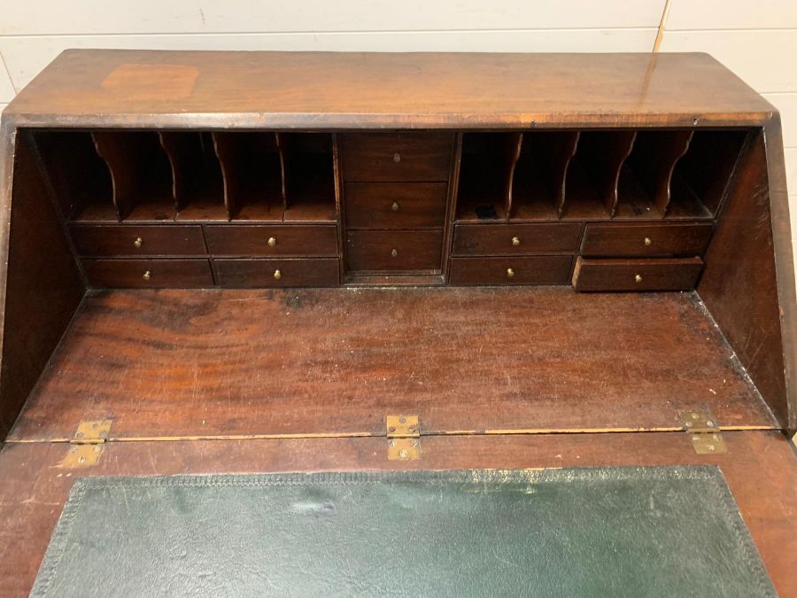 A George III mahogany bureau with sloping fall-front enclosing drawers and pigeonholes, with below 1 - Image 3 of 3