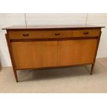 A Mid Century teak sideboard with pole style legs to side (H87cm W138cm D47cm)