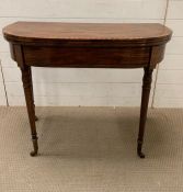 A Victorian card table, decorated with ebonised banding raised turned legs (H73cm W89cm D45cm)