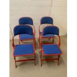 A Set of Four folding Sander metal chairs in red with blue seat pads.