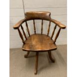 A Captains desk chair or elbow chair with spindle back and swivel base.