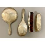 A Four piece silver dressing table set each with a circular cartouche, comprising mirror, hair and