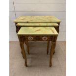 A nest of giltwood tables, inlaid with porcelain mounts and scroll details to side and legs (Largest