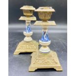 A pair of Delt and brass candlestick holders on square bases and bracket feet