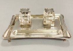 A silver desk set with glass inkwells with silver lids, dated 1909 by Charles and George Asprey (