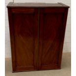 A two door mahogany cabinet converted to hand on a wall