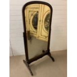 A Regency style mahogany cheval mirror between straight supports, terminating on carved feet and