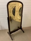 A Regency style mahogany cheval mirror between straight supports, terminating on carved feet and