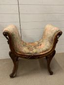 A window seat or stool with carved scrolling frame on turned legs