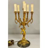 A six branch brass candelabra, in the form of male partially clad supporting the scrolling