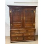 A George II style mahogany gentleman's linen press with brass handles and two paneled doors with