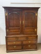 A George II style mahogany gentleman's linen press with brass handles and two paneled doors with