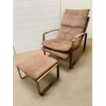 A suede armchair and foot stool, padded arm rests on powder coated base frame (H90cm W88cm)