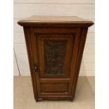 An oak bedside with carved centre panel (H76cm W42cm D36cm)