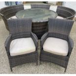 A rattan garden set to include two arm chairs, round table and four curved seats with cushions (