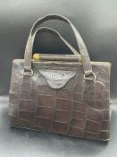 A Vintage crocodile handbag, with brass fittings and makers mark DL