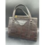 A Vintage crocodile handbag, with brass fittings and makers mark DL