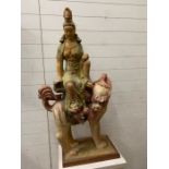 An oriental lady sat on a mythical beast possibly plaster (H130cm W51cm D32cm) (wooden plinth