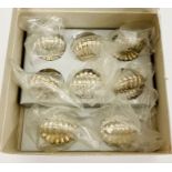 An Eight place setting box of shell themed place setting holders.