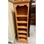 A narrow pine shelving unit