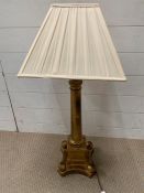 A gilt pillar table lamp and cream shade