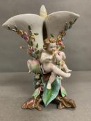 A Meissen three stem vase with foliate and floral decoration with three cherubs playing musical