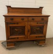 A Side cabinet with raised back, two drawers over a pair of carved doors on bracket feet. To the
