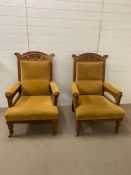 A Pair of open armchairs in gold velvet with carved backs.