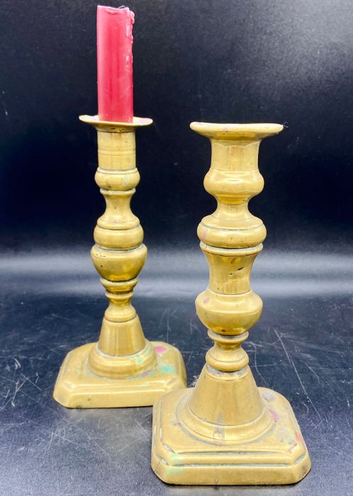 Two pairs of 19th century brass candlesticks with square bases and baluster stems (H25cm and H20cm)