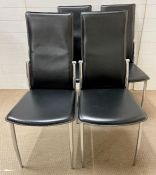 A set of four black chairs with chrome legs