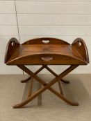 A mahogany butlers tray raised on a folding X shaped base (H67cm W65cm D49cm)