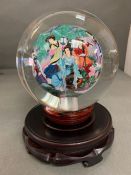 A hand painted oriental theme reverse painted glass paper weight globe with stand