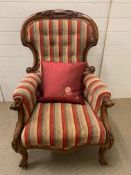 A Rococo style carved open armchair in striped upholstery, button back.