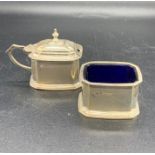 Two hallmarked silver cruets, mustard and salt with blue glass liners.