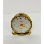 A Vintage Looping 15 jewel lever 8 day antimagnetic travel clock