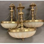 A trio of 1970's opaque glass and brass chandeliers