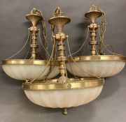 A trio of 1970's opaque glass and brass chandeliers