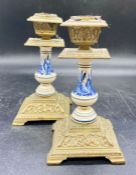 A pair of Delt and brass candlestick holders on square bases and bracket feet