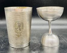 A white metal beaker and cup, machine tooled with blank cartouche.