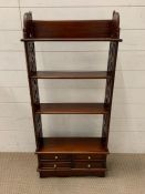 A mahogany floor standing bookcase with pierced work to sides and four small drawers to base (H105cm