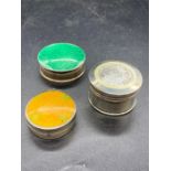 Three assorted silver pill boxes including one with a green enamel lid.