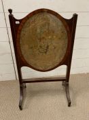 An inlay mahogany fire screen with needlework oval inset AF (76cm x 45cm)