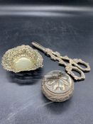 Three white metal items to include grape scissors, pierced pin dish, and a cockerel finial pot.