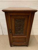 An oak bedside with carved centre panel (H76cm W42cm D36cm)