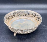 A pierced silver bowl on three feel (Total weight 68g), hallmarked for 1915 by Henry Williamson Ltd