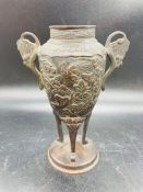 A two handled Oriental bronzed urn with bird design.