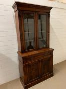 A Mahogany bookcase, upper section with two glazed doors, lower section with carved doors (W 103