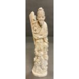 An Ivory figure of a man standing with a child at his feet.